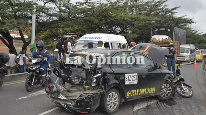 Este taxi negro de placa EYZ253 terminó impactado al punto que quedó en sentido contrario de la vía.