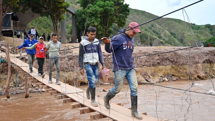 Pasajeros cruzan el río Tarrita por un improvisado puente de madera/Foto Jorge Gutíerrez/La Opinión