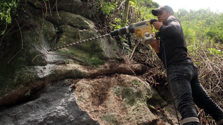  Intentan abrir un paso provisional en medio de la montaña, para poder llegar hasta las otras veredas. Aquí intentan destruir la roca, que obstaculiza el camino. / Foto: Carlos Eduardo Ramírez / La Opinión 