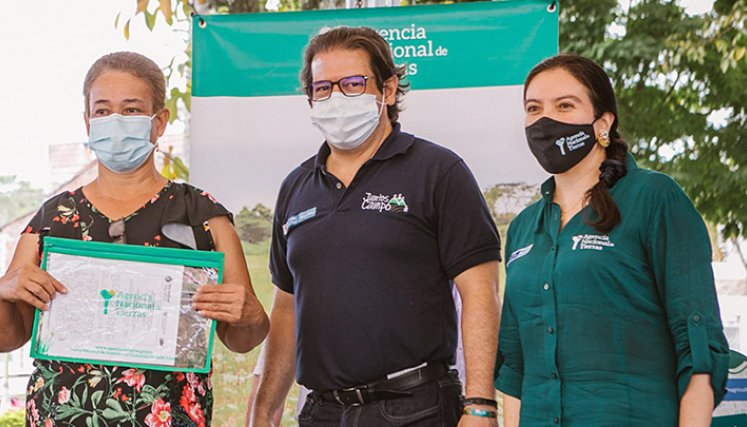 La directora de la ANT, Myriam Martínez, y el ministro de Agricultura, Rodolfo Zea, entregando los documentos de propiedad.