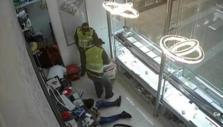 Los dos falsos policías y un tercer individuo usaron un saco para empacar varias joyas y dinero en efectivo: / Foto: Captura de video