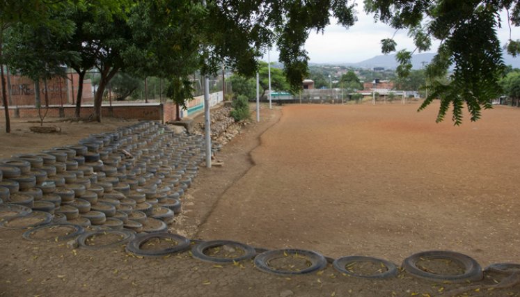 Gradería de llantas en la cancha de tierra del barrio. 