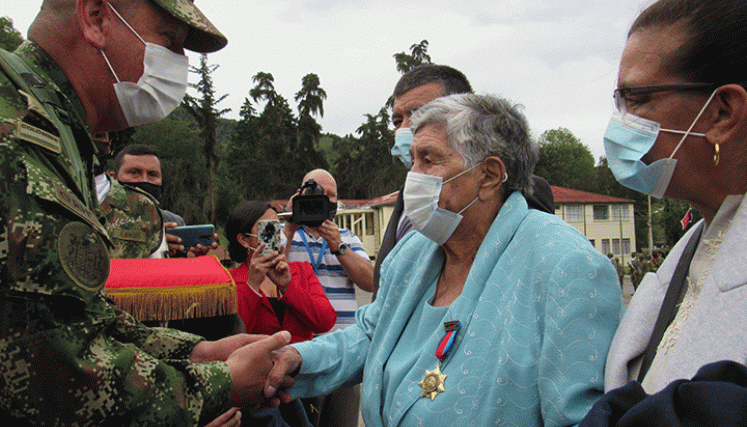El brigadier Jhon Sánchez le impuso la medalla a doña Mercedes Flórez. / Roberto Ospino/ La Opinión 