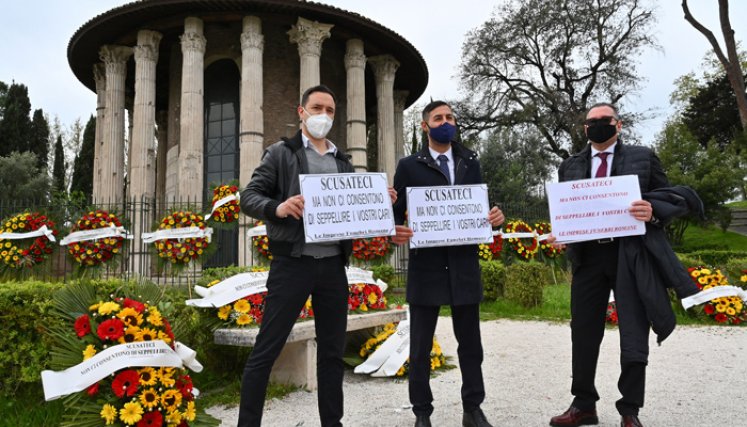 Trabajadores de las funerarias sostienen carteles que dicen: "Disculpas, pero no nos dejan enterrar a tus seres queridos", mientras protestan en el antiguo templo circular romano contra la interrupción de los servicios funerarios debido al creciente número de muertes causadas por la COVID-19. / Foto: AFP