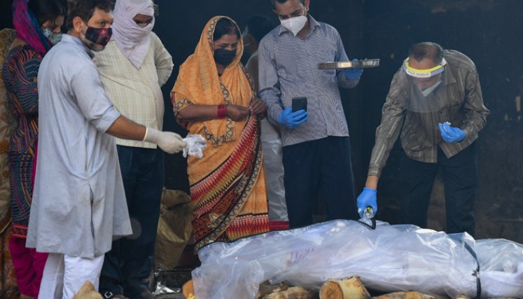 Familiares realizan los últimos ritos por su ser querido que murió de coronavirus, antes de la cremación en Moradabad, en India. / Foto: AFP
