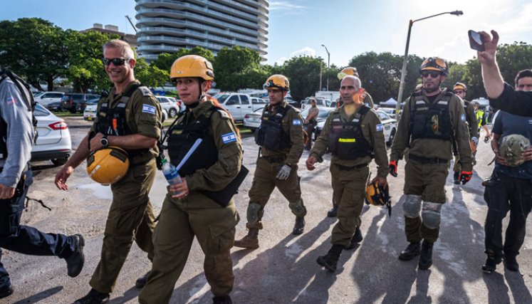 Los miembros de la delegación de Israel Rescuers se reúnen a su llegada al área cerca del edificio de condominios Champlain Towers South de 12 pisos parcialmente derrumbado en la ciudad de Surfside, Florida, el 27 de junio de 2021. / Foto: AFP