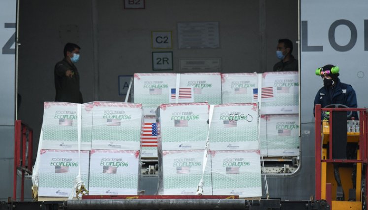 Miembros de la Fuerza Aérea Colombiana descargan 2.5 millones de dosis de la vacuna COVID-19 Janssen donada por Estados Unidos, en el Aeropuerto Internacional El Dorado. / Foto: AFP