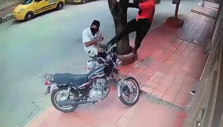 En cámaras de seguridad quedó grabado el momento en el que un hombre se acerca a una moto estacionada sobre un andén. Atento de no ser percibido intenta arrebatar la tapa del motor y otra parte del vehículo. / Foto: Captura de video