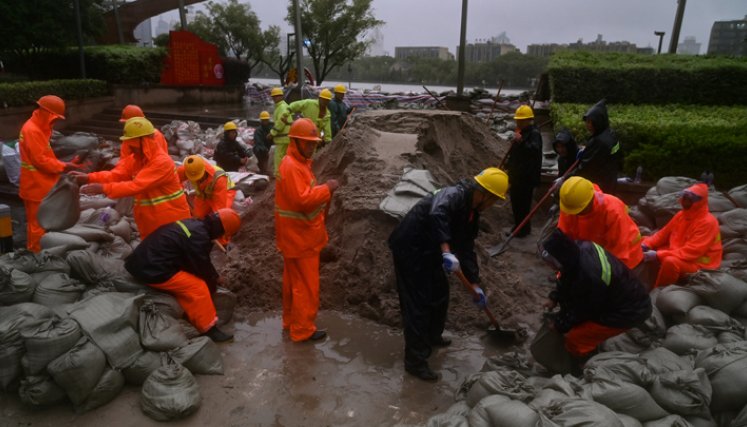 Un equipo prepara sacos de arena junto al río Yuyao en Ningbo, provincia de Zhejiang, en el este de China, este domingo, mientras el tifón In-Fa azota la costa este de China.