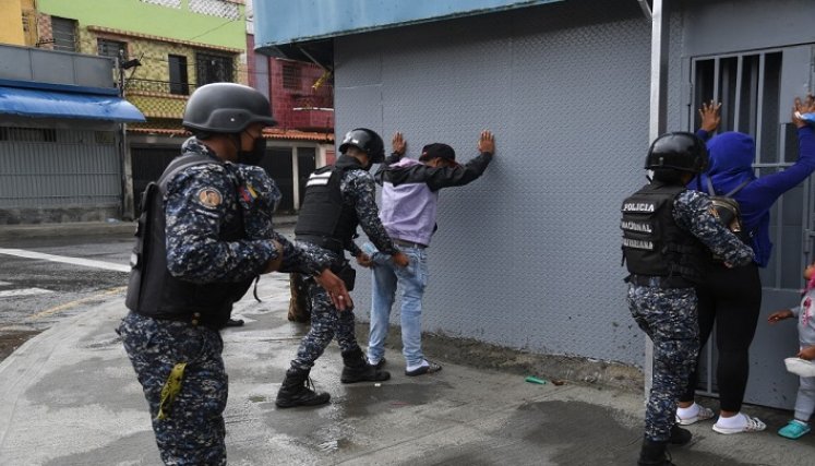 Miembros de la Policía Nacional Bolivariana requisan a personas durante enfrentamientos con presuntos integrantes de una banda criminal./Foto: AFP