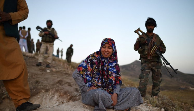 Salima Mazari (centro), una gobernadora de distrito en un Afganistán dominado por hombres, mirando desde una colina mientras está acompañada por personal de seguridad cerca de la línea del frente contra los talibanes en el distrito de Charkint en la provincia de Balkh.  / Foto: AFP