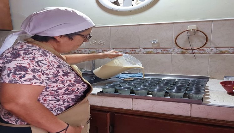 De manera acuciosa la monja prepara las delicias para atraer a los turistas.