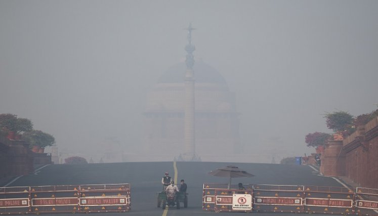 La gente tiene que caminar en medio de condiciones de niebla tóxica en Nueva Delhi el 20 de noviembre de 2021./AFP