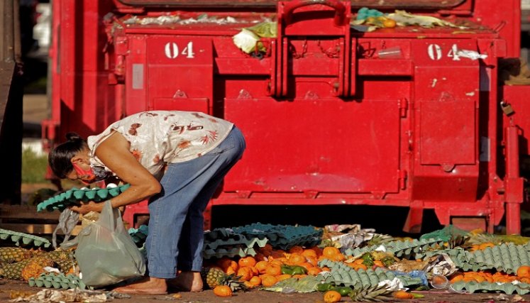 La gente recolecta frutas y verduras descartadas por los vendedores ambulantes en Belem, estado de Pará, Brasil. /AFP