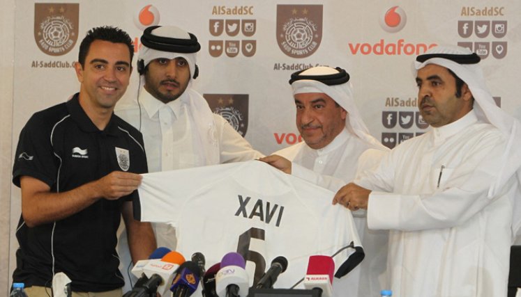 En esta foto de archivo, la leyenda del Barcelona Xavi Hernández (izquierda) posa para una foto con Jassim Al Rumaihi, secretario general del club de fútbol Al-Sadd, y representantes del club. / Foto. AFP