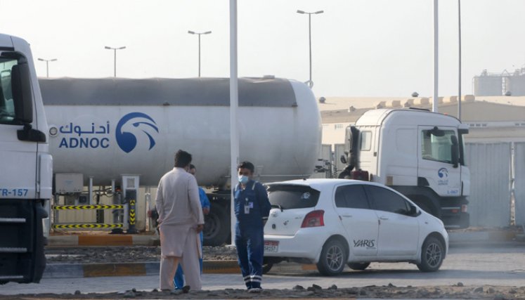 Los hombres se paran frente a una instalación de almacenamiento del gigante petrolero ADNOC en la capital de los Emiratos Árabes Unidos, Abu Dhabi, el 17 de enero de 2022. Tres personas murieron en un presunto ataque. / Foto: AFP