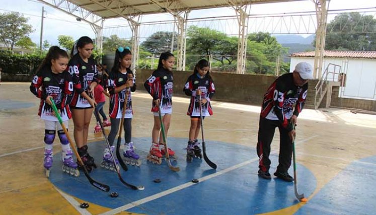 El instructor de hockey en línea, el profesor Luis Ernesto Higuera en una de las prácticas con sus alumnas.