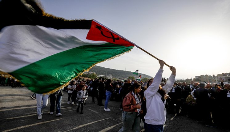 Árabe-israelíes marchan con una bandera palestina 