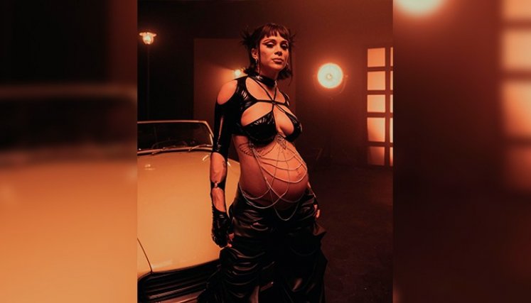 Con su abdomen pronunciado, un crop top tipo bikini, manga larga y un pantalón negro, la cantante anunció el nuevo disco. 