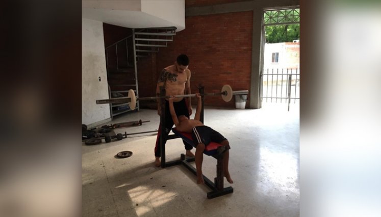 Brayan enseña a uno de sus atletas a fortalecer los brazos, parte esencial en los movimientos del parkour.