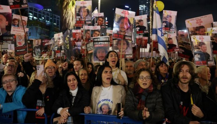 Familiares sostienen pancartas con retratos de rehenes israelíes retenidos en Gaza.