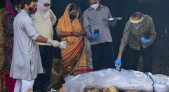 Familiares realizan los últimos ritos por su ser querido que murió de coronavirus, antes de la cremación en Moradabad, en India. / Foto: AFP