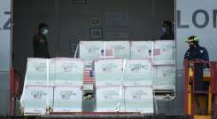 Miembros de la Fuerza Aérea Colombiana descargan 2.5 millones de dosis de la vacuna COVID-19 Janssen donada por Estados Unidos, en el Aeropuerto Internacional El Dorado. / Foto: AFP
