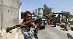 Un combatiente talibán sostiene un cohete RPG mientras hace guardia con otros en una puerta de entrada fuera del Ministerio del Interior en Kabul. / Foto: AFP