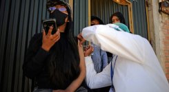 Una mujer es inoculada contra COVID-19 con la vacuna china SinoPharm por personal del Ministerio de Salud de Bolivia, afuera de su casa en el barrio Santa Rosa en El Alto, Bolivia.  / Foto: AFP