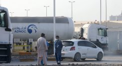 Los hombres se paran frente a una instalación de almacenamiento del gigante petrolero ADNOC en la capital de los Emiratos Árabes Unidos, Abu Dhabi, el 17 de enero de 2022. Tres personas murieron en un presunto ataque. / Foto: AFP