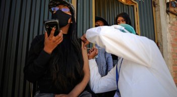 Una mujer es inoculada contra COVID-19 con la vacuna china SinoPharm por personal del Ministerio de Salud de Bolivia, afuera de su casa en el barrio Santa Rosa en El Alto, Bolivia.  / Foto: AFP