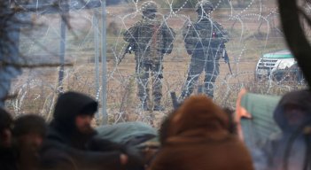 Militares polacos detrás de una cerca de alambre de púas en la frontera entre Bielorrusia y Polonia