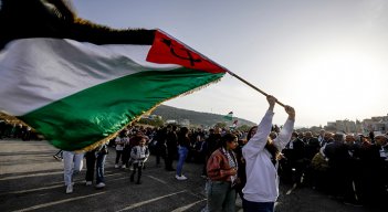 Árabe-israelíes marchan con una bandera palestina 