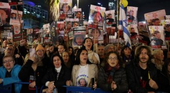 Familiares sostienen pancartas con retratos de rehenes israelíes retenidos en Gaza.